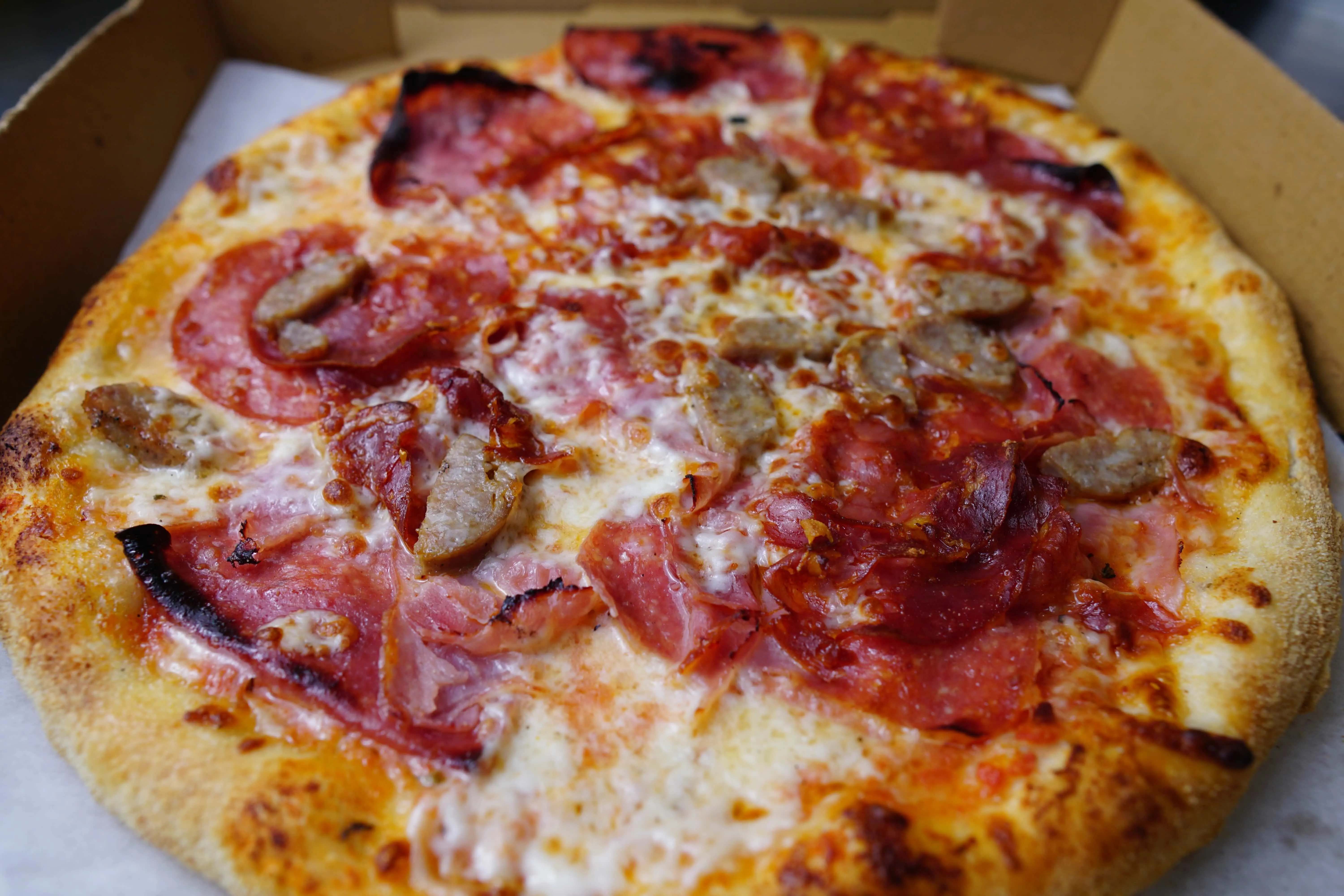A hand-stretched pizza fresh from one of The Bus Pizza's Italian ovens